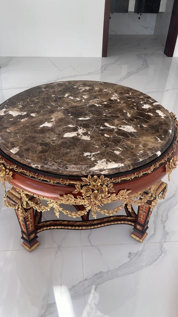 Ornate antique oval center table with a marble top and elaborate gold carvings on a dark wood base.